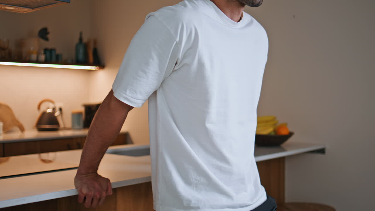 Sporty man practicing dips on kitchen counter at home fitness routine closeup