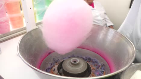 preparation of cotton candy twisting with stick at fair