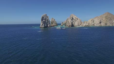 Toma-Aerea-De-La-Panoramica-De-Las-Formaciones-Rocosas-En-El-Arco-De-Los-Cabos-Con-Lanchas-Y-Yates,-Baja-California-Sur