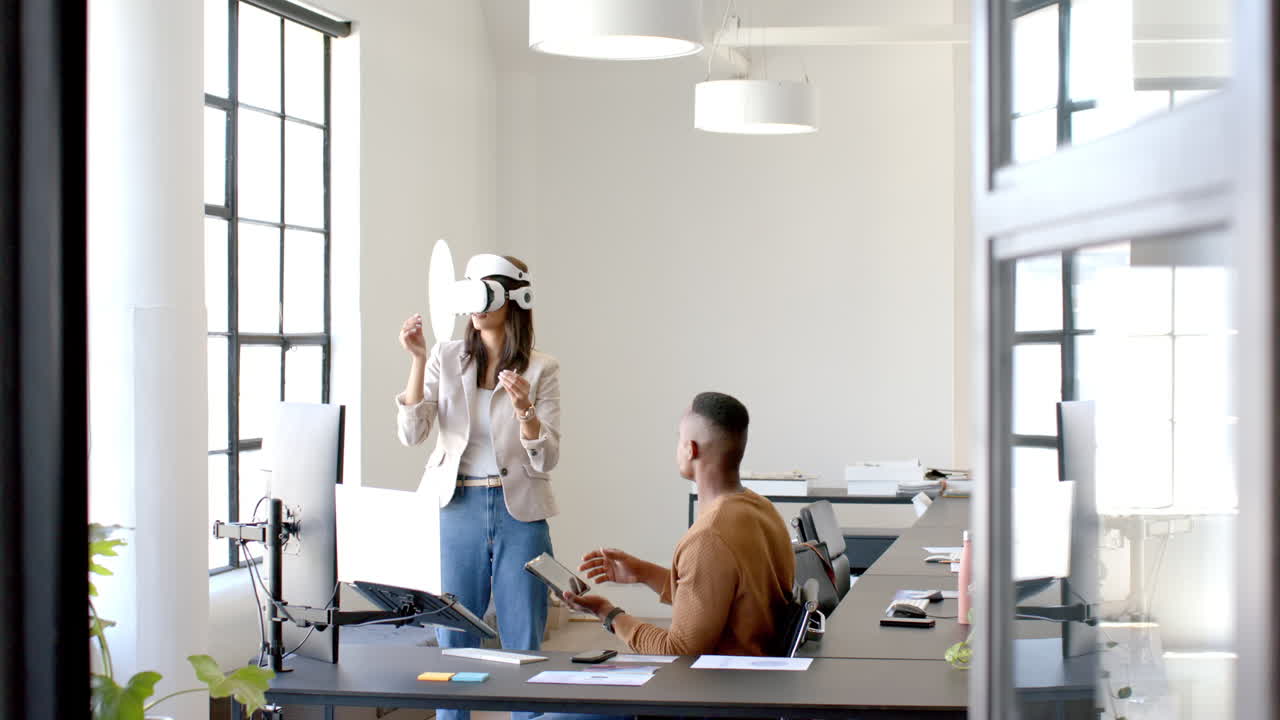 Using VR headset, woman collaborating with colleague in modern office setting