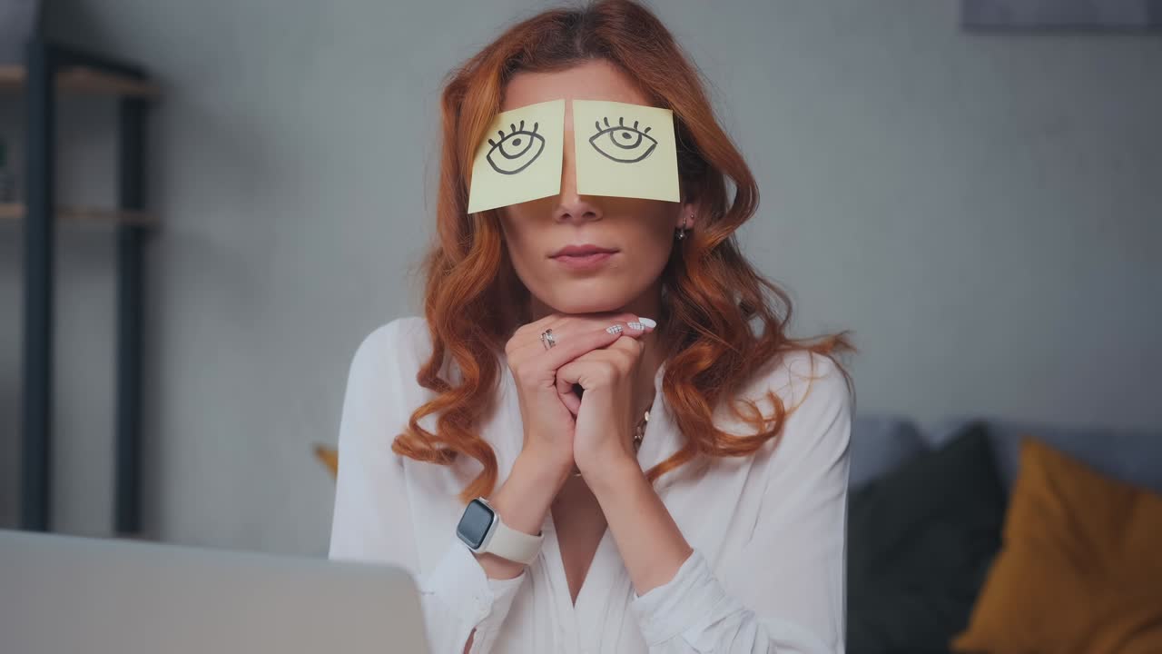 Lazy caucasian woman with funny stickers on eyes sleeps at workplace in office