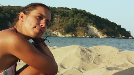 chica sentada en la playa mirando el mar