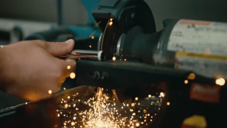 golf club builder using saw to cut iron shaft in slow motion, sparks flying close up in 4k