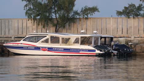 transport ferry moored at port in cambodia, people passing over waterfront