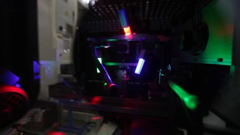 interior of a complex machine with vibrant neon lights, reflecting advanced technology and intricate design in dim lighting