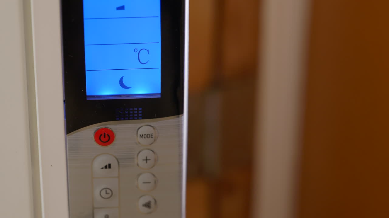 persona presionando el botón bajando la temperatura ambiente para ahorrar energía, cerrar