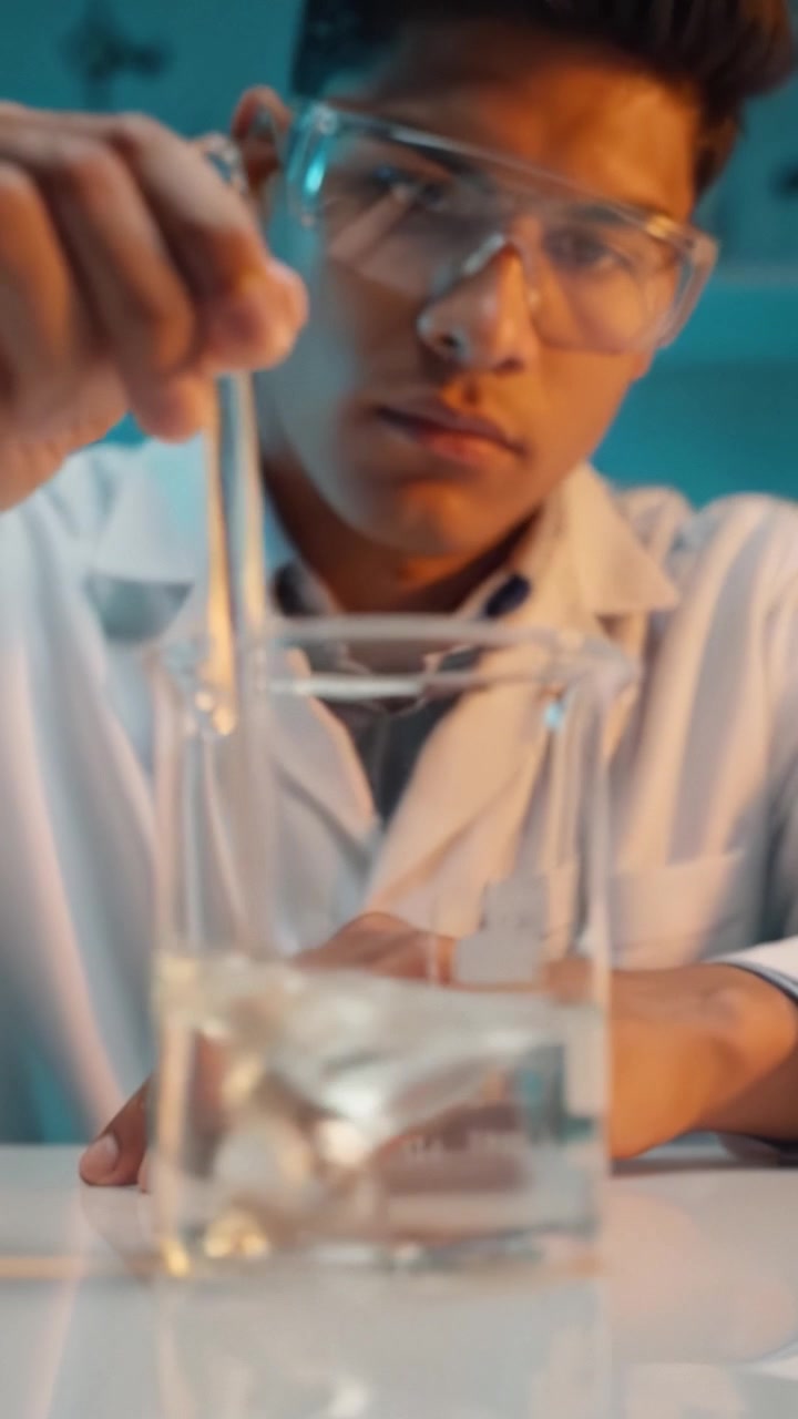 Young Scientist Conducting Experiment in Laboratory: A Focused Researcher Analyzes Liquid Solutions with Precision Lab Equipment for Advanced Science Exploration