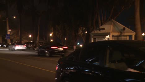 a car travels along a street at night in santa monica california as seen through the rear window at an angle 5