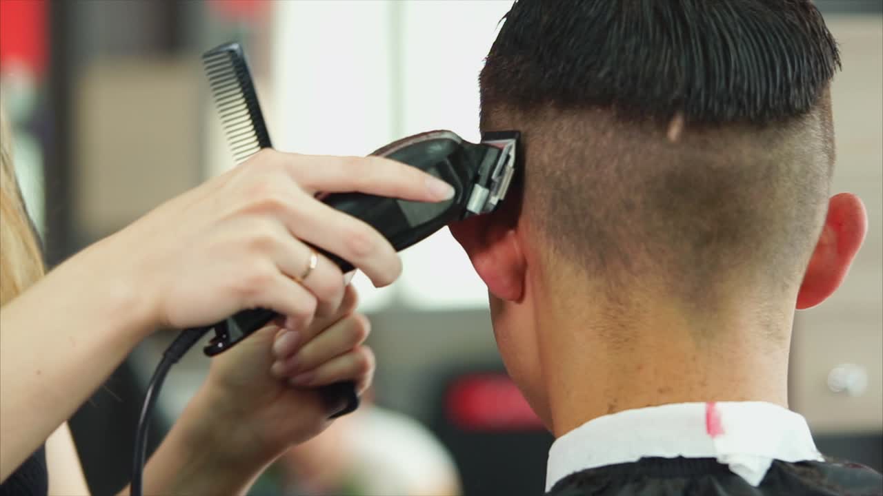 un hombre se corta el cabello en una barbería.