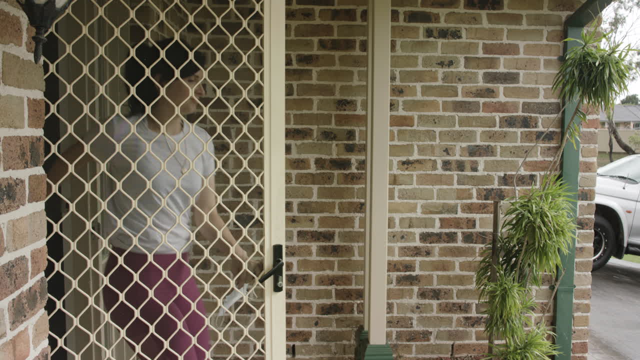 la mujer sale de casa con ropa activa, se pone una máscara y sale a correr