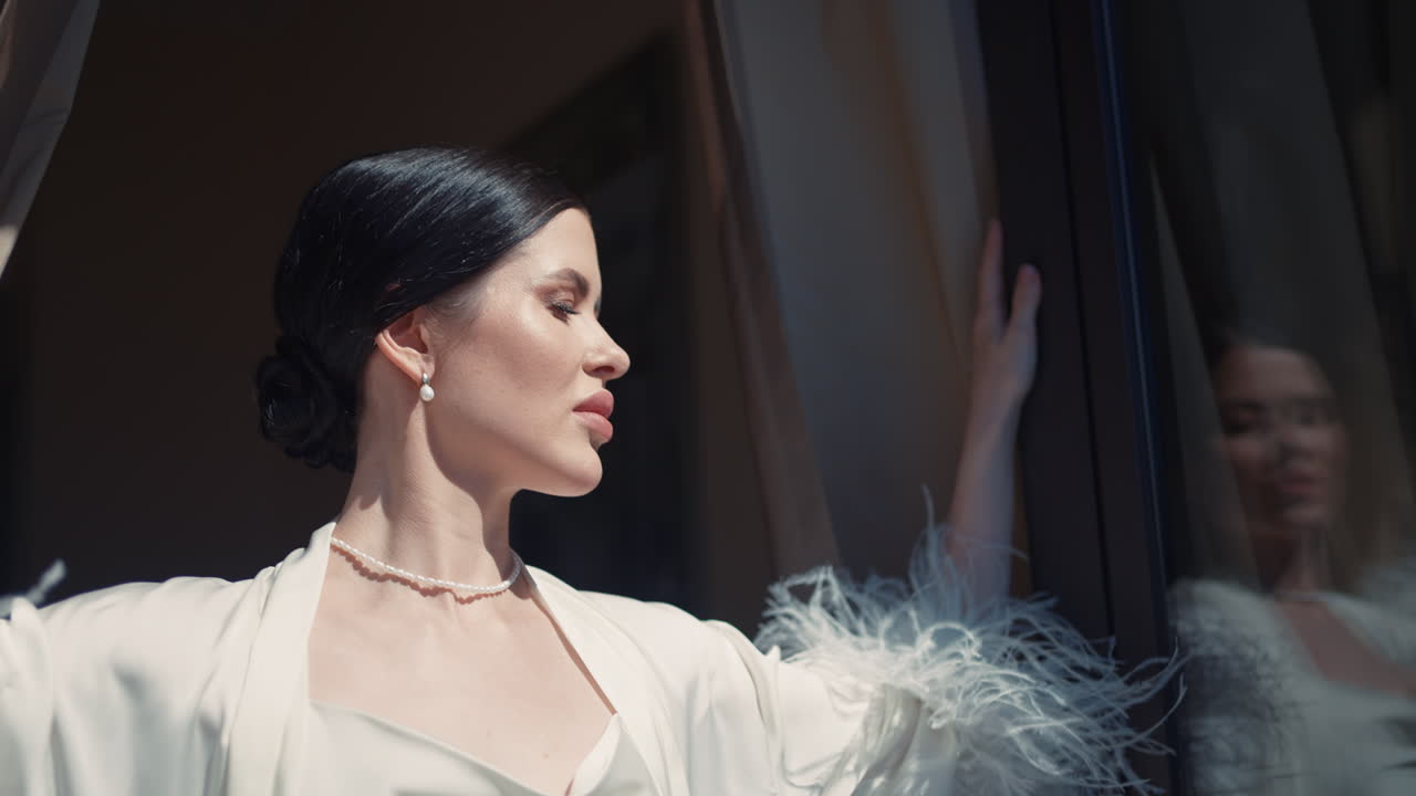 Woman in a white robe by the window