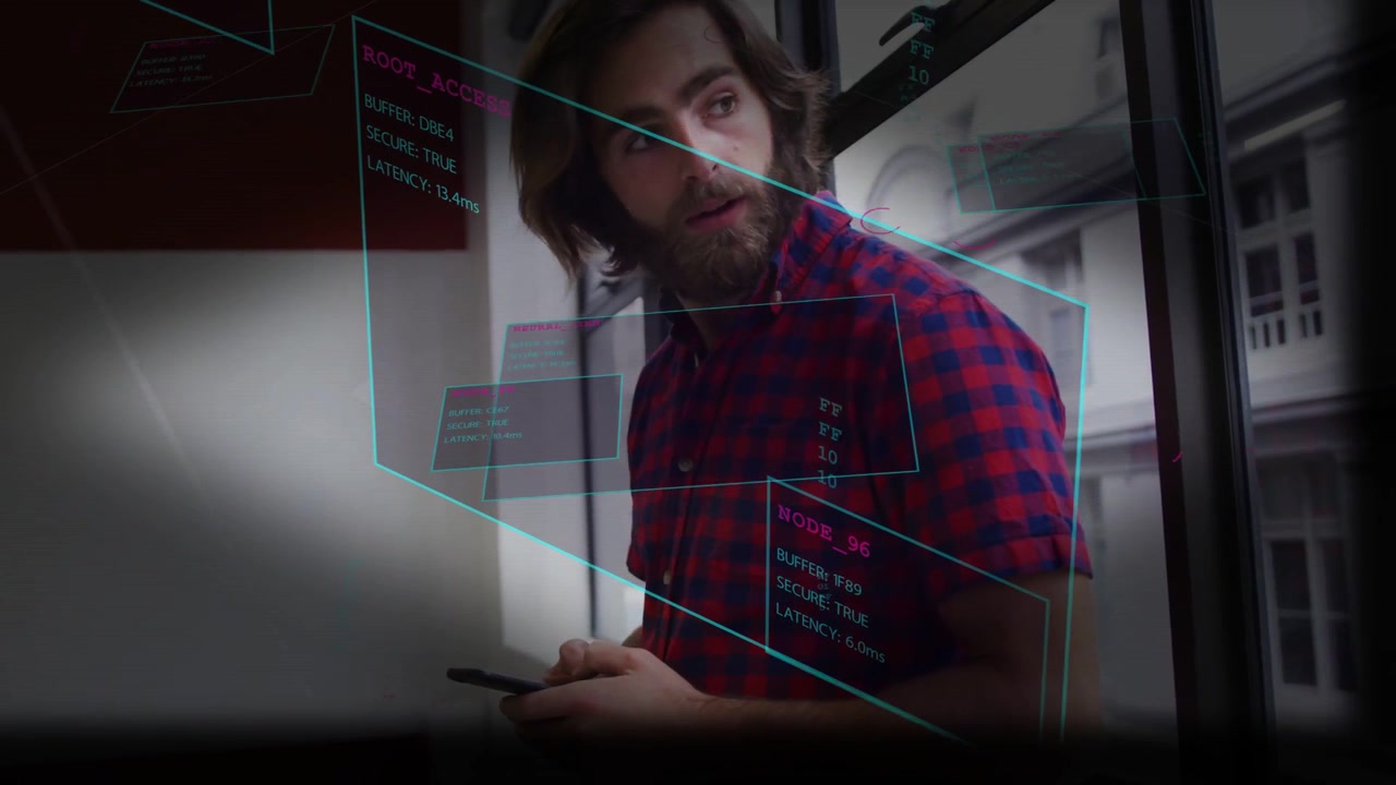Mand tapper på telefon nær vinduespaneler, der sporer torsoen og viser en cyan magenta brugerflade, mens han tjekker teknologi.