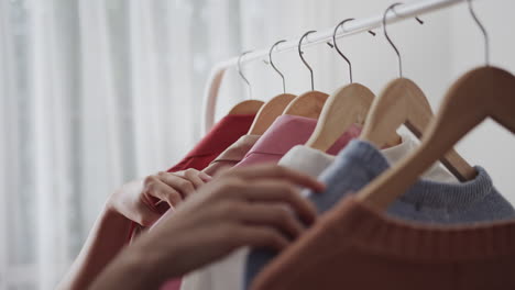 Faceless-woman-looking-for-his-blouse-size-in-a-store-while-shopping-clothes,-hands-close-up