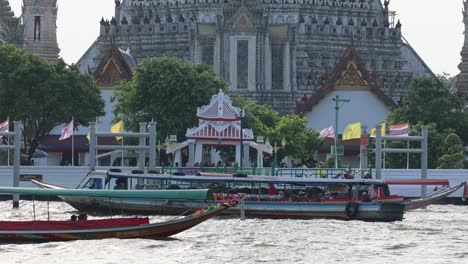boats moving on river in front of temple