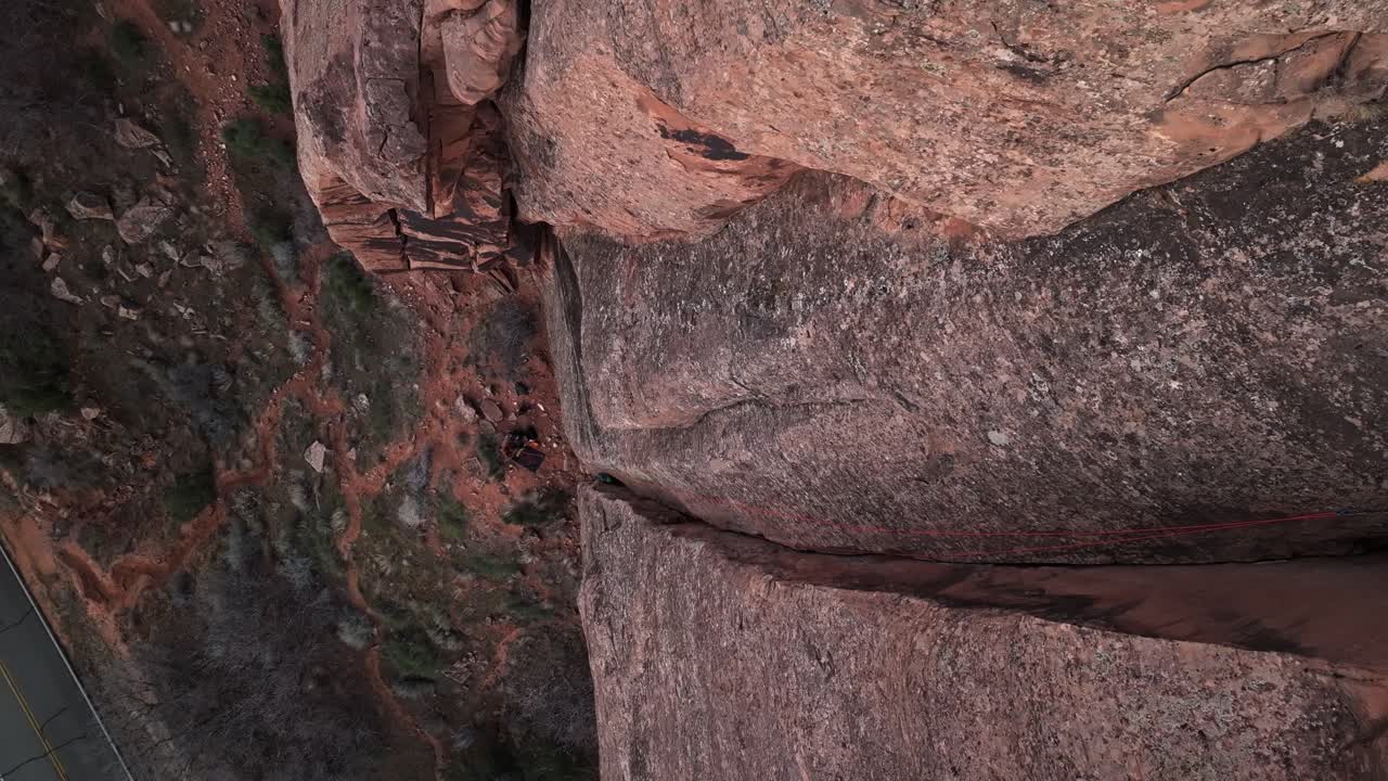 Aerial Moab sandstone fissures at sunset, golden light dramatic desert rock formations, top down orbit