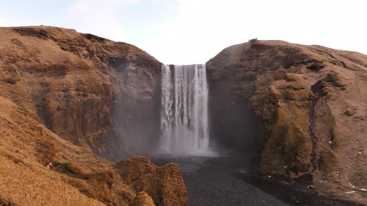 Waterfall Skógafoss, located in Skógar, Iceland, with surrounding mountains and misty atmosphere
