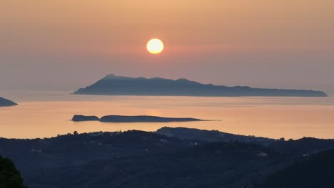 sunset view over corfu island, greece with serene ionic sea and orange sky