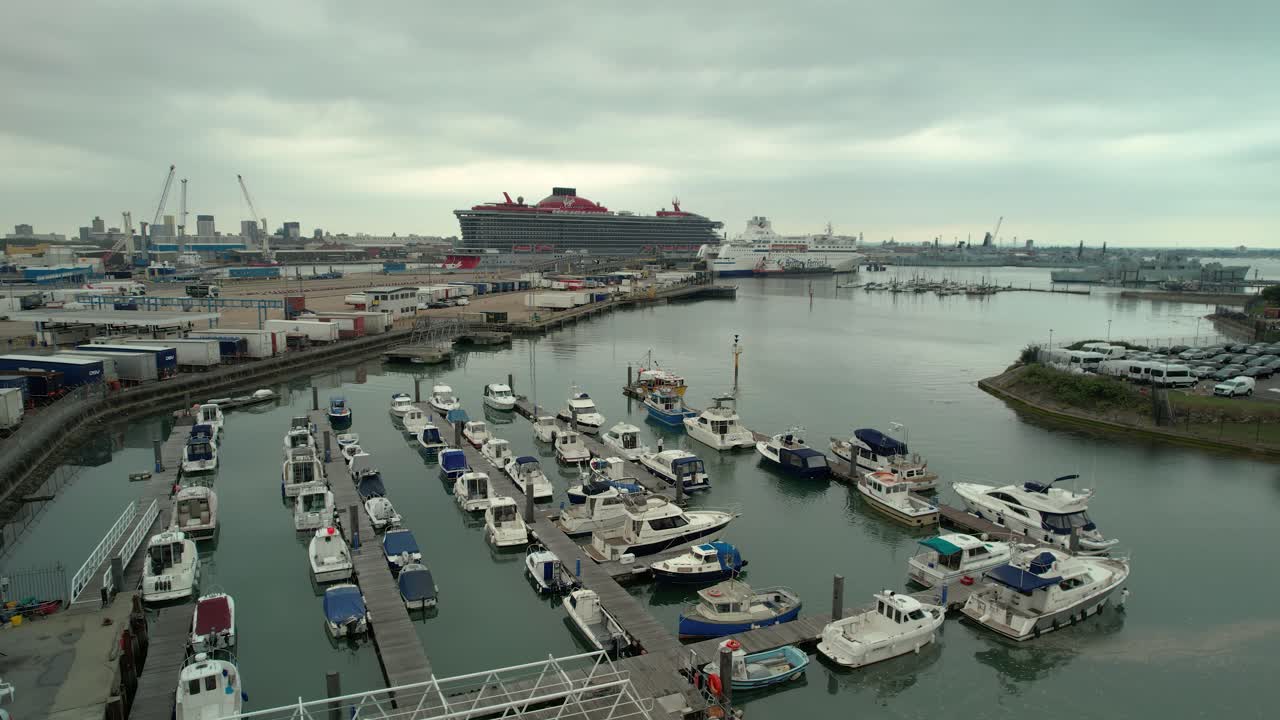 영국 포트머스 터미널에 정박한 버진 보이저 스칼렛 레이디 유람선과 함께 부두에 정박한 보트