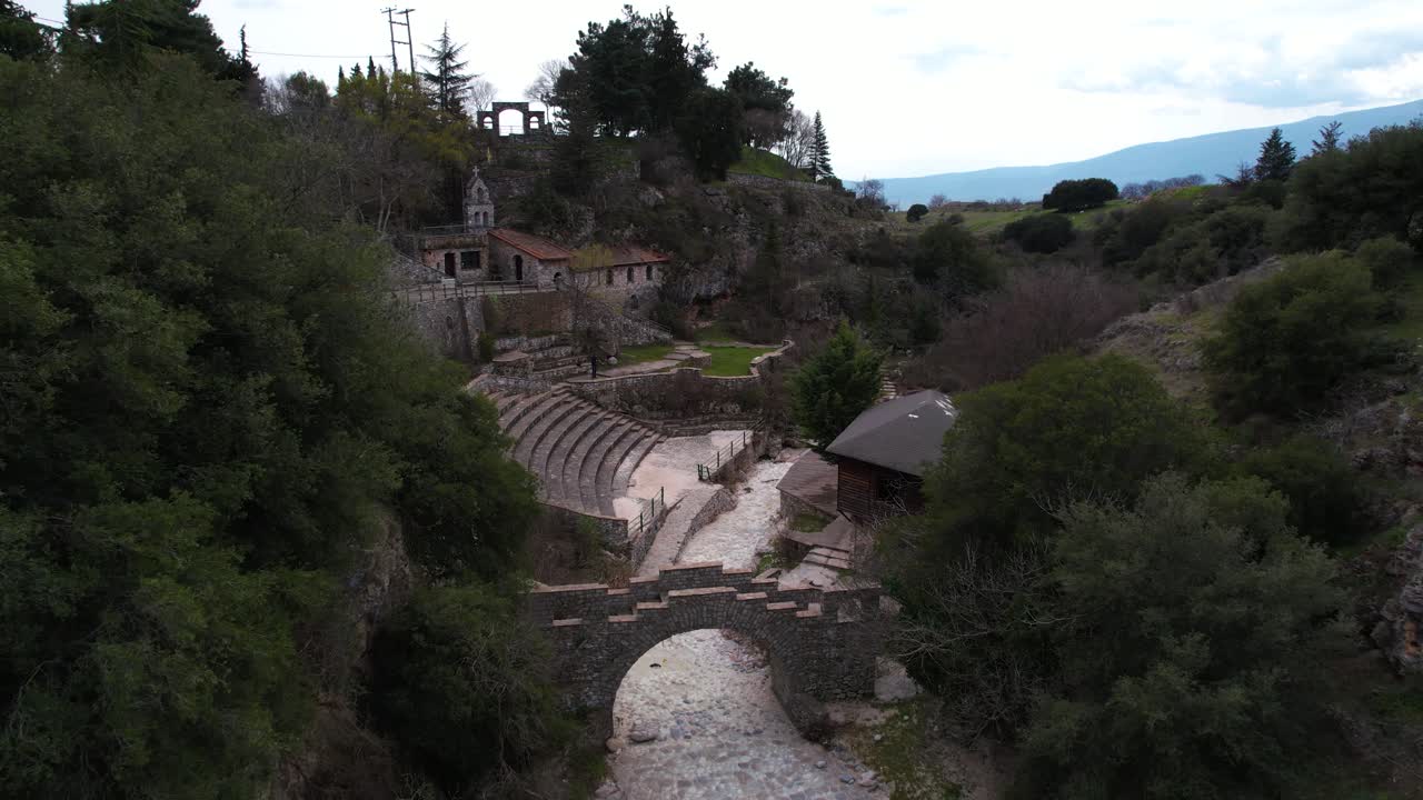 Gola di Petrousa a Drama, Grecia. Carrellata aerea sul teatro all'aperto e sulla zona del ponte di pietra, passaggio stretto e natura scenografica.
