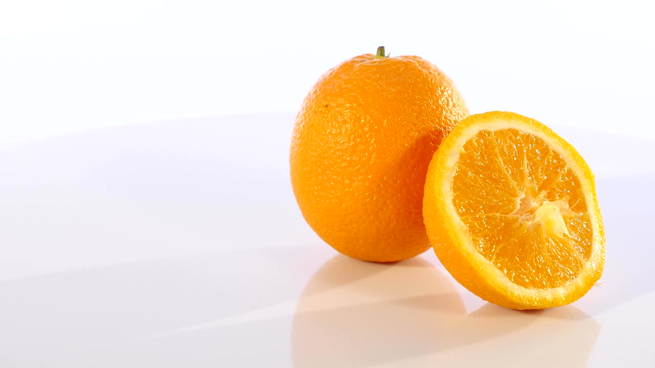 Appelsinskiver roterende på hvid