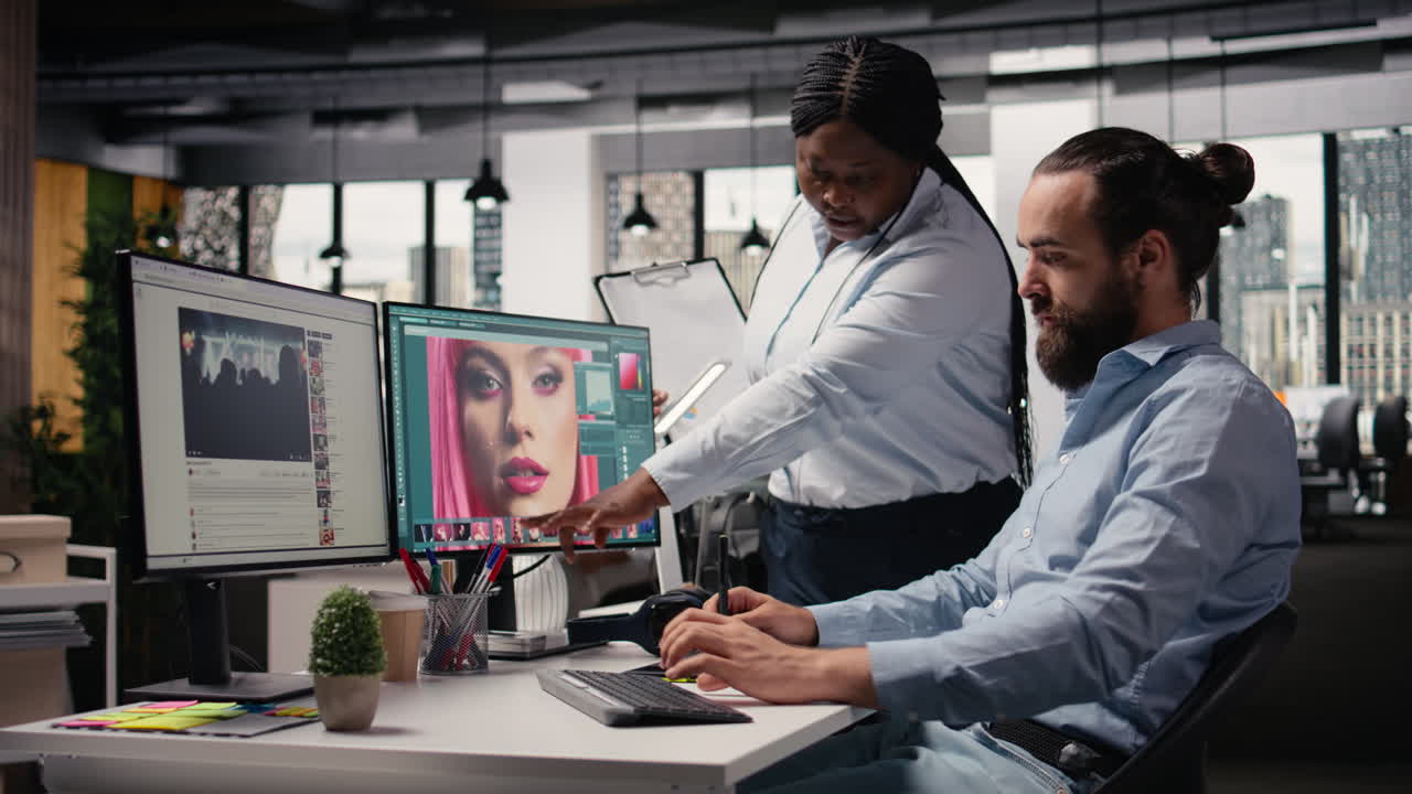 Due fotoritoccatori al lavoro sulla selezione e modifica delle immagini con software di ritocco.