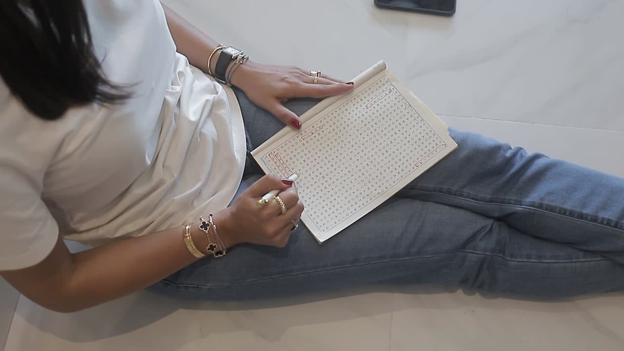 Young woman sitting on floor at home solving alphabet soup, close up shot