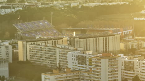 Aerial:-La-Mosson's-tramway-lines-glide-beneath-the-towering-antenna,-surrounded