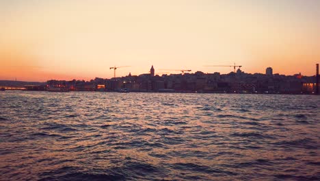 slow motion: landscape view of galate tower and bosphorus at sunset while cruising in istanbul,turkey