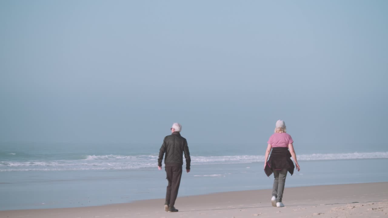 Elderly Couple Walking Together  on the Beach
