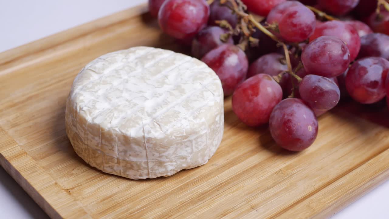 나무 판자에 있는 치즈와 포도