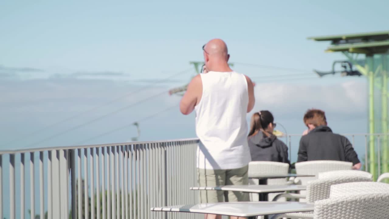 케이블카 와 함께 산 꼭대기 레스토랑 에서 전망 을 즐기는 사람 들