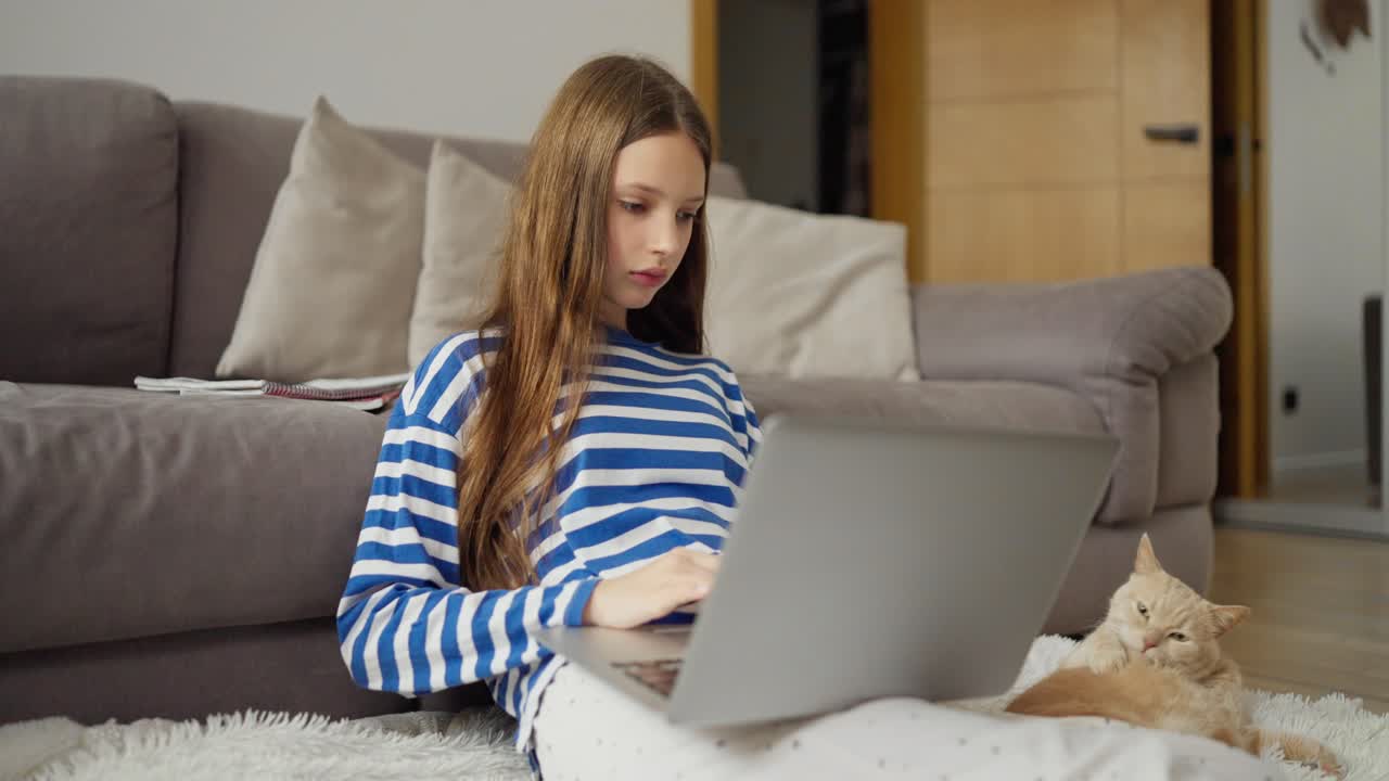 Teenager using laptop with cat
