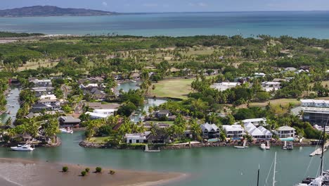 denarau island, viti levu, fiji - a panorama of the marina featuring waterfront luxurious homes, boats, and yachts moored near the shore - aerial drone shot