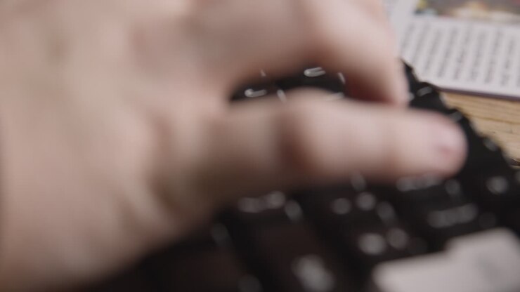 Person Using Keyboard Next To Newspaper Headline Discussing Extreme Weather Conditions And Floods In Global Warming Crisis