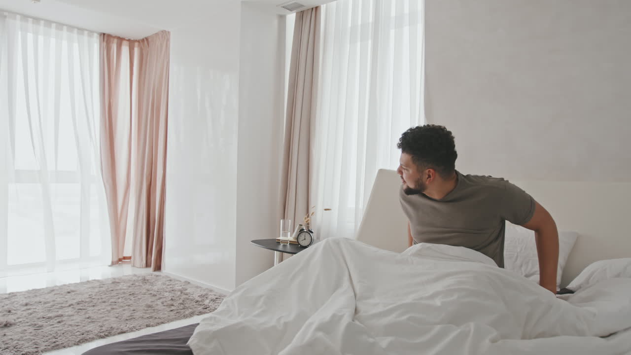 Handsome Man Waking Up And Stretching In Bed
