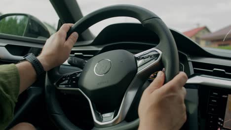 manos del conductor en el volante de un coche moderno