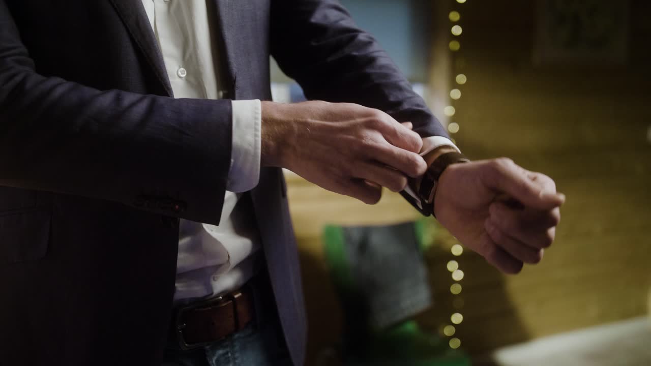 남자는 소매를 조정하고 크리스마스를 준비합니다.