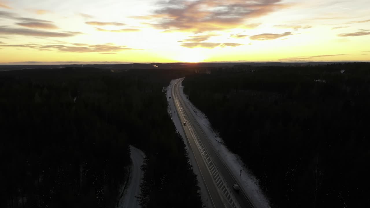 coches circulando por una carretera helada durante la puesta de sol en una fría noche de invierno en suecia