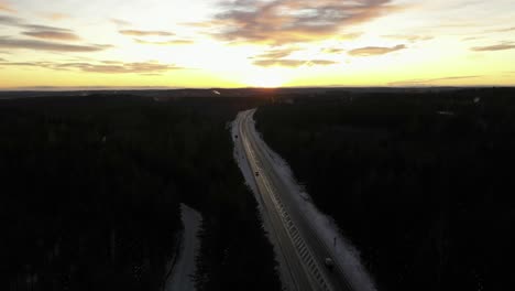 cars driving on an icy road during sunset on a cold winter evening in sweden