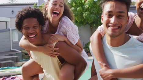 group of two happy diverse male friends carrying piggyback female friends at pool party