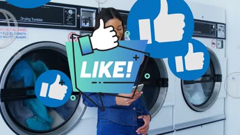 Animation-of-like-text-over-african-american-woman-using-smartphone-at-public-laundromat