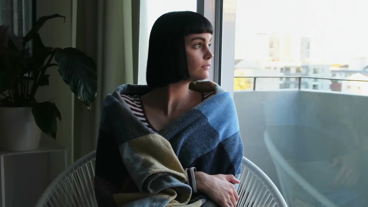 거실에서 휴식을 취하는 담요로 싸인 여자 4k