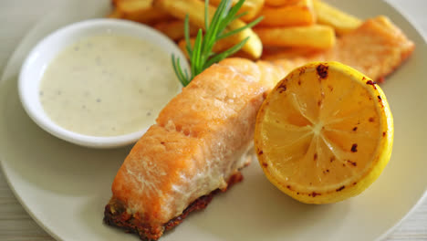 pescado frito con salmón y patatas fritas con limón en el plato