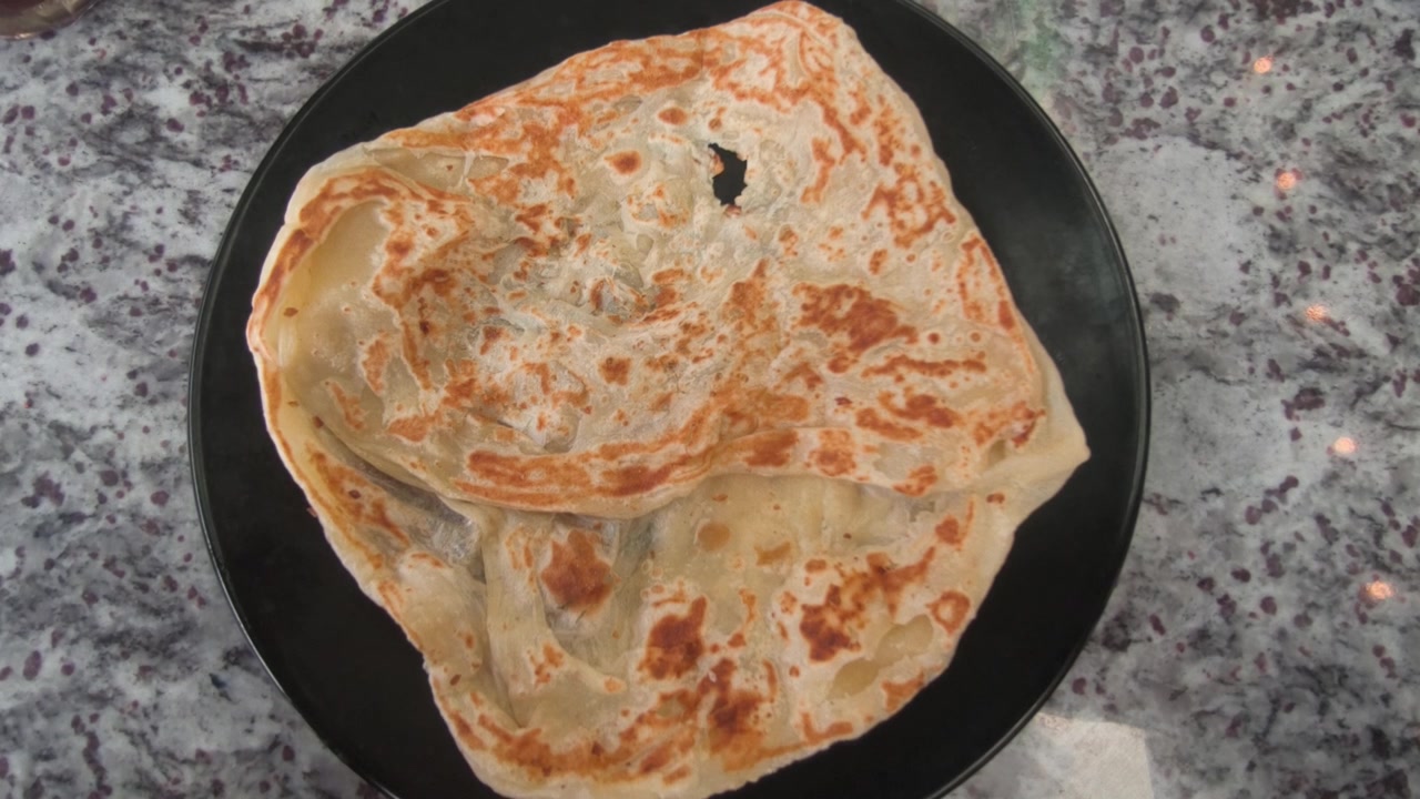Sepotong roti canai klasik disajikan di piring dengan kari dhal gurih. Ini melambangkan persiapan dasar dan pokok hidangan tersebut di Malaysia. Hidangan ini tetap sangat populer untuk sarapan.