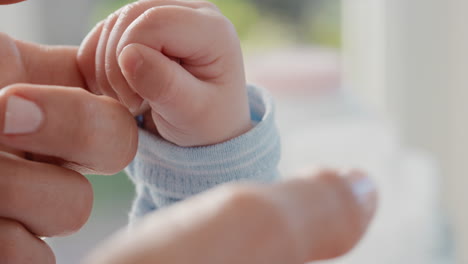 close up mother holding baby hand touching fingers mom nurturing newborn caring for infant at home motherhood love 4k