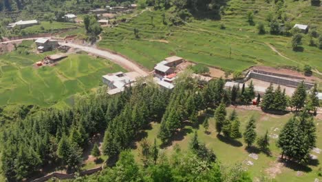 aerial over green landscape with buildings at gabin jabba in pakistan