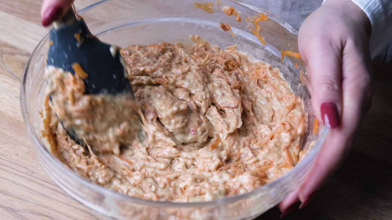 Hands Mixing Ingredients For Carrot Cake Baking In A Glass Bowl