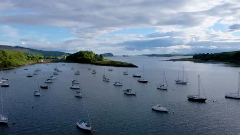 imágenes aéreas de drones de 4k que se acercan a los veleros atracados en el lago cerca de las tierras altas escocesas de escocia