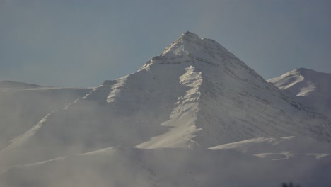 snow-covered mountain peak with mist at the base