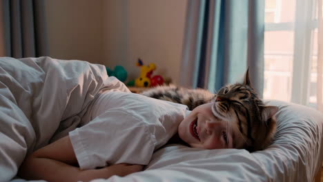 boy and cat lying in bed